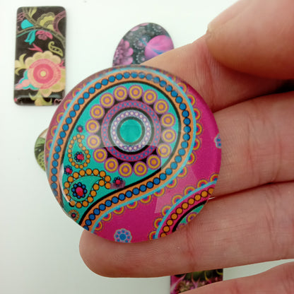 Colorful mandala-patterned object held by a hand on a white background