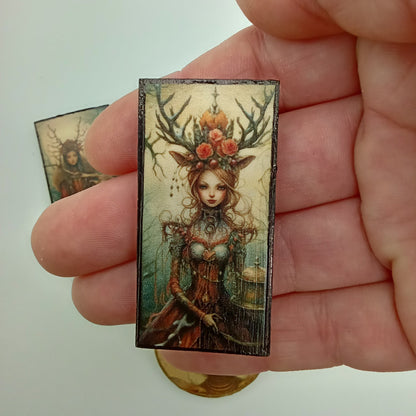 Hand holding a rectangular decorative item with intricate design on a plain background